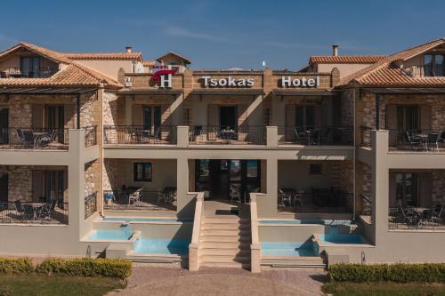 a large building with a hotel with stairs and tables at Tsokas Hotel in Finikounta