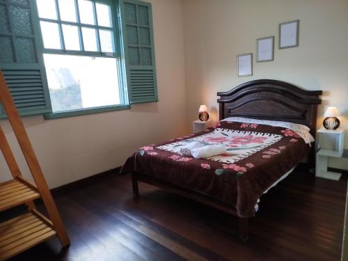a bedroom with a bed and a window at Casinha da Lela in Ouro Preto