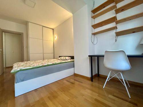 a bedroom with a bed and a desk and a chair at Joy Cafe&Bakery Apartments in Skopje