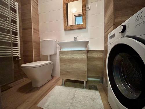a bathroom with a sink and a toilet and a washing machine at Joy Cafe&Bakery Apartments in Skopje