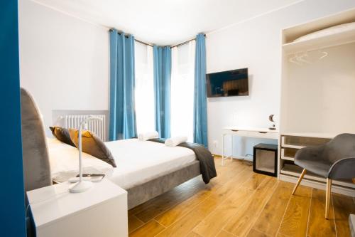 una camera da letto con letto con tende blu e scrivania di Arre Mida a Bari