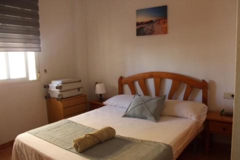 - une chambre avec un lit doté d'une tête de lit en bois dans l'établissement VACATION NEAR THE SEA. (POOL-SHOPS-RESTAURANTS), à Torrevieja