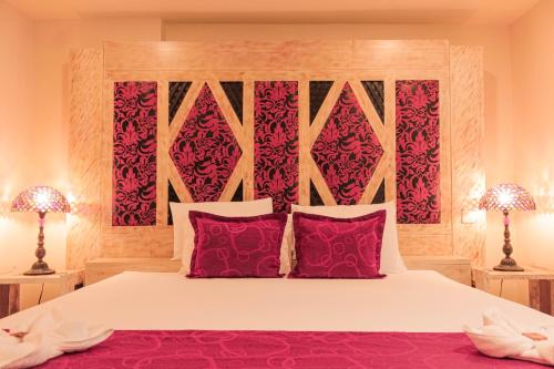 a bedroom with a large bed with red pillows at Hotel Plaza Garibaldi in Caldas