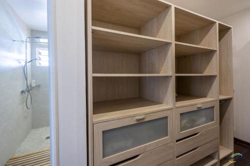 a closet in a bathroom with wooden shelves at Villa Cap Sud avec piscine et vue mer in Les Anses-dʼArlets