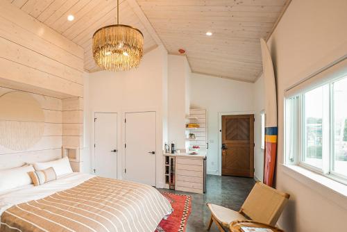 um quarto com uma cama, uma cadeira e um lustre em Funboard Room includes King Bed and Mini Kitchenette em Stinson Beach