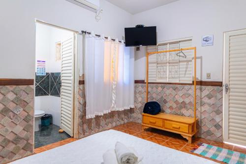 - une chambre avec une douche, un lit et une télévision dans l'établissement Pousada Meia Lua, à Pirenópolis