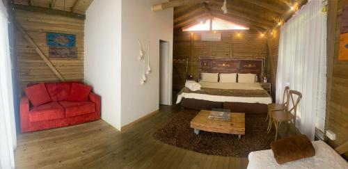 a bedroom with a bed and a red couch at Hotel Casa Madero in Envigado