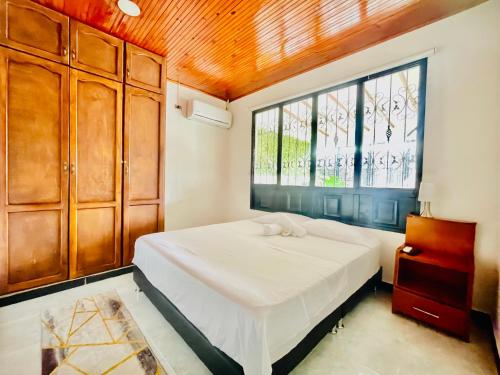 sypialnia z białym łóżkiem i oknem w obiekcie De Greiff House w San José Del Guaviare