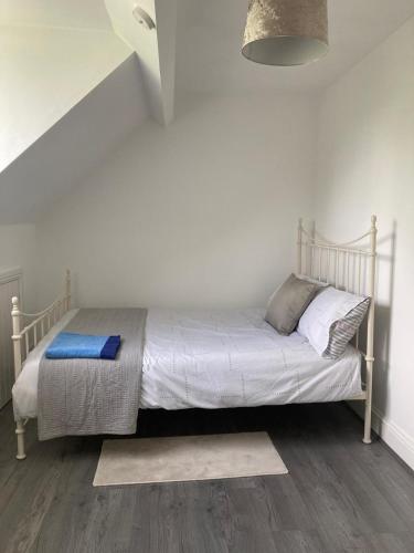 uma cama num quarto com uma parede branca em Springhome Newport em Newport