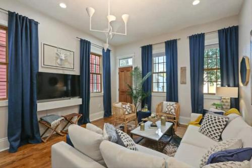 a living room with white furniture and blue drapes at Designer Home Walking Distance To The French Quarter's in New Orleans