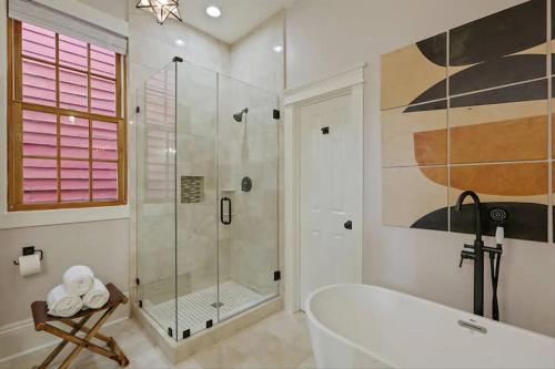 a bathroom with a tub and a glass shower at Designer Home Walking Distance To The French Quarter's in New Orleans