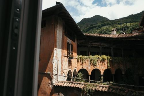 a building with a balcony with a mountain in the background at Charme nel Borgo di Bienno di Design, Natura & Relax in Bienno