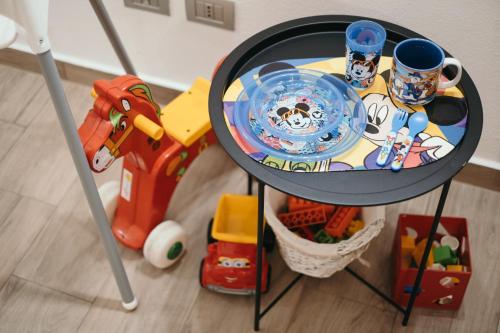 a table with a plate and cups and toys on it at Charme nel Borgo di Bienno di Design, Natura & Relax in Bienno