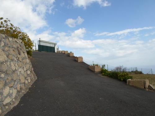 una carretera que conduce a un edificio en la cima de una colina en Finca Las Polinarias Casa Cueva en Fasnia en Santa Cruz de Tenerife
