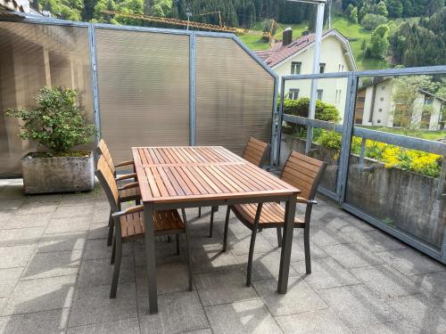 a wooden table and chairs on a balcony at Titlis Lodge Engelberg in Engelberg