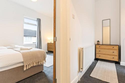 a bedroom with a bed and a dresser and a mirror at Herschell House - Central Location - Free Parking, Fast Wifi, SmartTV with Netflix - Perfect for Contractors, Families and Groups by Yoko Property in Redcar
