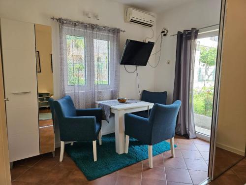 a room with a table and chairs and a television at Apartments Carpe Diem in Kotor
