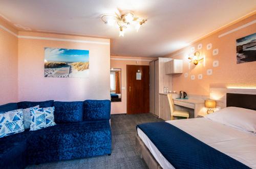 ein Hotelzimmer mit einem Bett und einem Sofa in der Unterkunft Villa Dora in Mielno