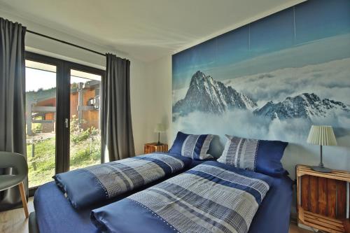 上斯陶芬的住宿－Ferienwohnung Hochsiedel，一间带两张床的卧室和山壁画