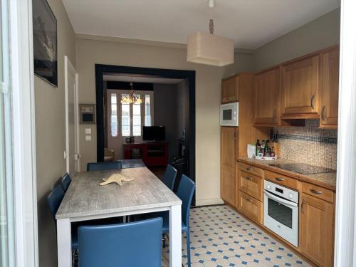 - une cuisine avec une table et des chaises bleues dans la chambre dans l'établissement Le Havre de Quentovic pour six personnes, à Le Touquet-Paris-Plage
