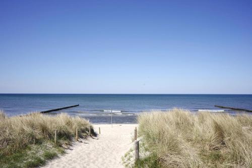 a sandy beach with the ocean in the background at Achtern Diek 12c - Wohnung 3 in Müggenburg