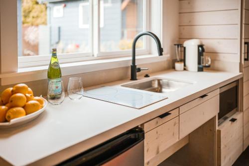 a kitchen counter with a bowl of oranges and a bottle of wine at Longboard Studio includes King Bed and Kitchenette in Stinson Beach