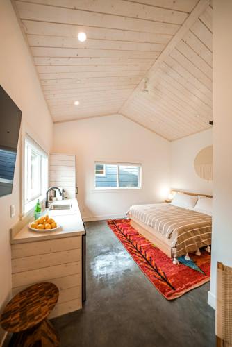1 dormitorio con 1 cama y lavamanos en una habitación en Longboard Studio includes King Bed and Kitchenette, en Stinson Beach