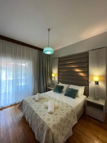 a bedroom with a large bed and a large window at Maria Apartments in Paralia Dionysiou