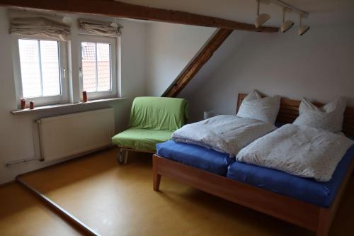 - une chambre avec un lit et une chaise verte dans l'établissement Ferienhaus Anno 1720, à Wernigerode