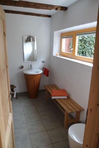 a bathroom with a sink and a toilet and a bench at Ferienhaus Anno 1720 in Wernigerode