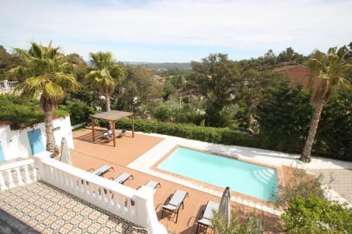 uitzicht op een zwembad met stoelen en een tafel bij Pool Oasis with Mountain Views in Maçanet de la Selva