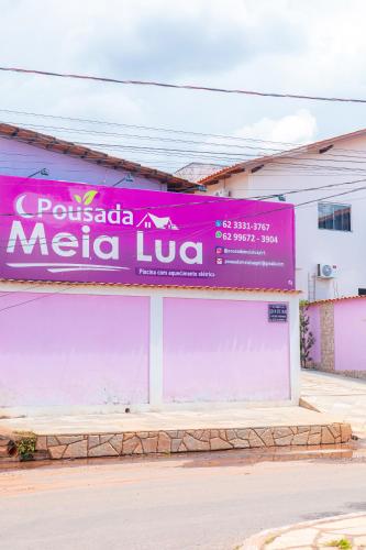 a pink sign on the side of a building at Pousada Meia Lua in Pirenópolis