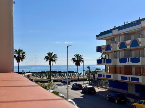 vistas a un edificio y a la playa con palmeras en Casa Alma del mar en Montesilvano