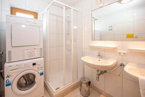 a bathroom with a washing machine and a sink at Almhäuser Filzsteinalpe Almhaus 197 in Krimml