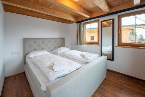 a bedroom with a large bed with white sheets at Almhäuser Filzsteinalpe Almhaus 204 in Krimml