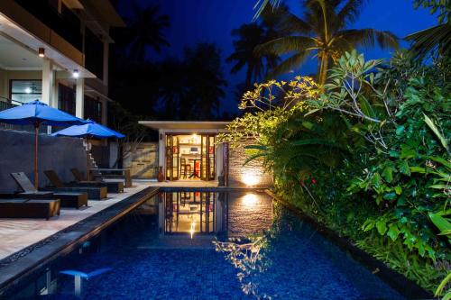 a villa with a swimming pool at night at Melasa House in Senggigi 