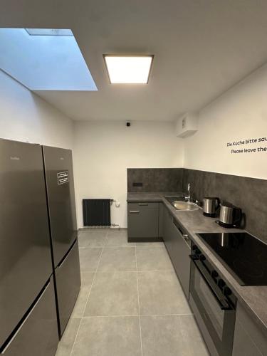 eine Küche mit Küchengeräten aus Edelstahl und einer Spüle in der Unterkunft EasyLiving Darmstadt in Darmstadt