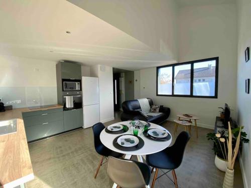 ポワティエにあるLe Tropical, Maison T3 - 55m2のキッチンとテーブルと椅子のあるリビングルーム
