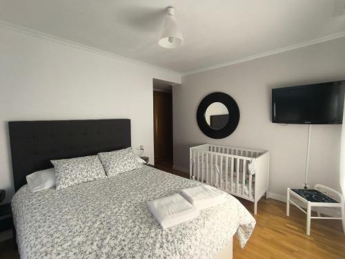 sypialnia z łóżkiem i łóżeczkiem dziecięcym oraz telewizorem z płaskim ekranem w obiekcie LA VAGUADA w mieście Zamora