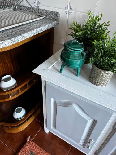 a green pot sitting on top of a white cabinet at D'Oliva Gerês - River Side Houses in Geres