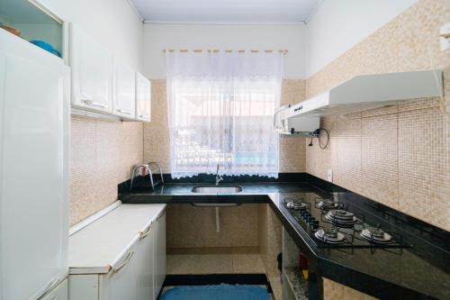 a small kitchen with a sink and a stove at Pousada Meia Lua in Pirenópolis