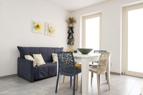 a living room with a couch and a table and chairs at Appartamento Clalia in Luino