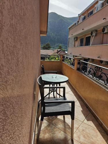 a table and chair on the balcony of a building at Apartments Carpe Diem in Kotor