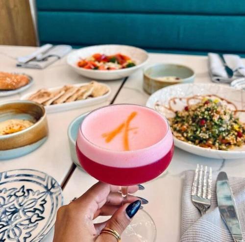 a person is holding a drink with a carrot on it at Luxury Condo at Harbour Walk in Red Bay Estate