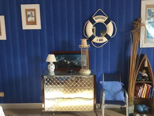 Cette chambre est dotée d'un mur bleu avec une table et une chaise. dans l'établissement Maison sur la plage de Kerleven, à La Forêt-Fouesnant