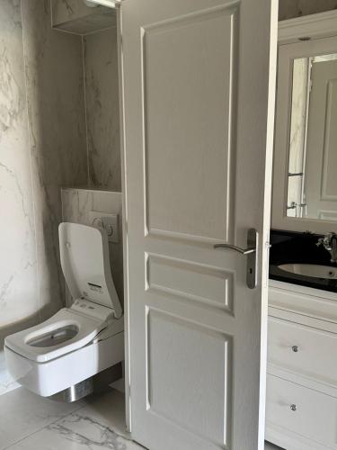 a bathroom door with a toilet and a sink at Vue sur Tour Eiffel in Issy-les-Moulineaux