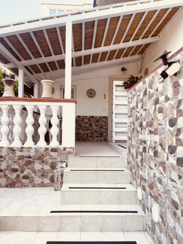 a porch with stairs and a stone wall at Goriziana Garden Home in Tropea