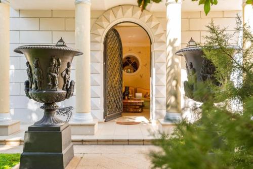 an entry to a house with two urns at Villa ITO in La Spezia