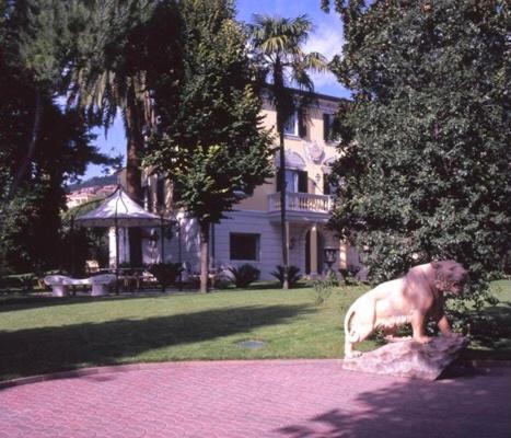 a dog sitting on a rock in front of a house at Villa ITO in La Spezia