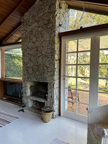 ペトロポリスにあるQuinta 59 - Sua Casa na Serraのガラスの引き戸があるリビングルームの石造りの暖炉